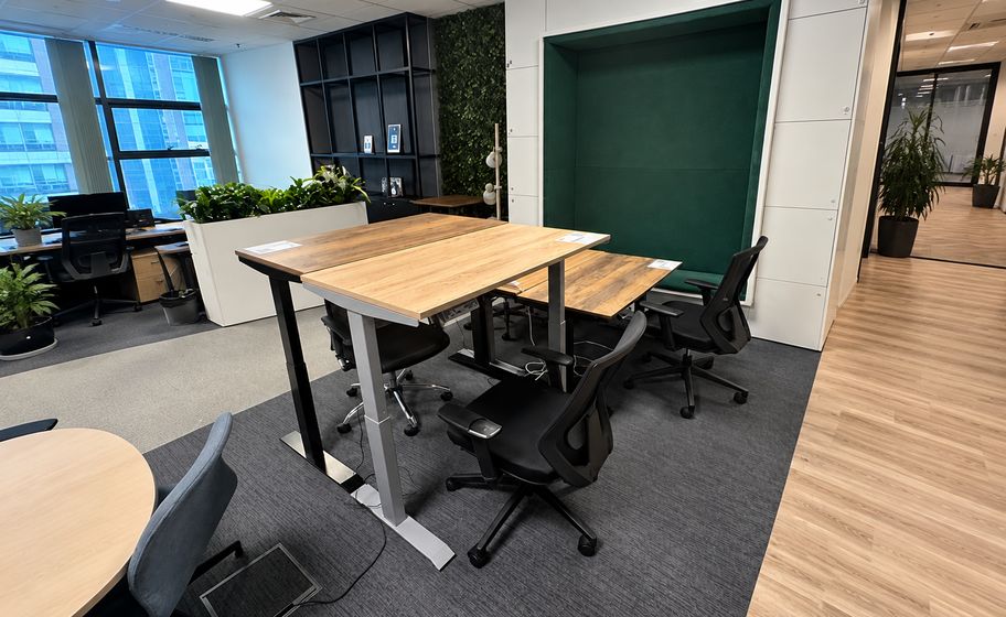 Dřevěný stůl s černými židlemi v coworkingu aSpace Floreasca v Bukurešti