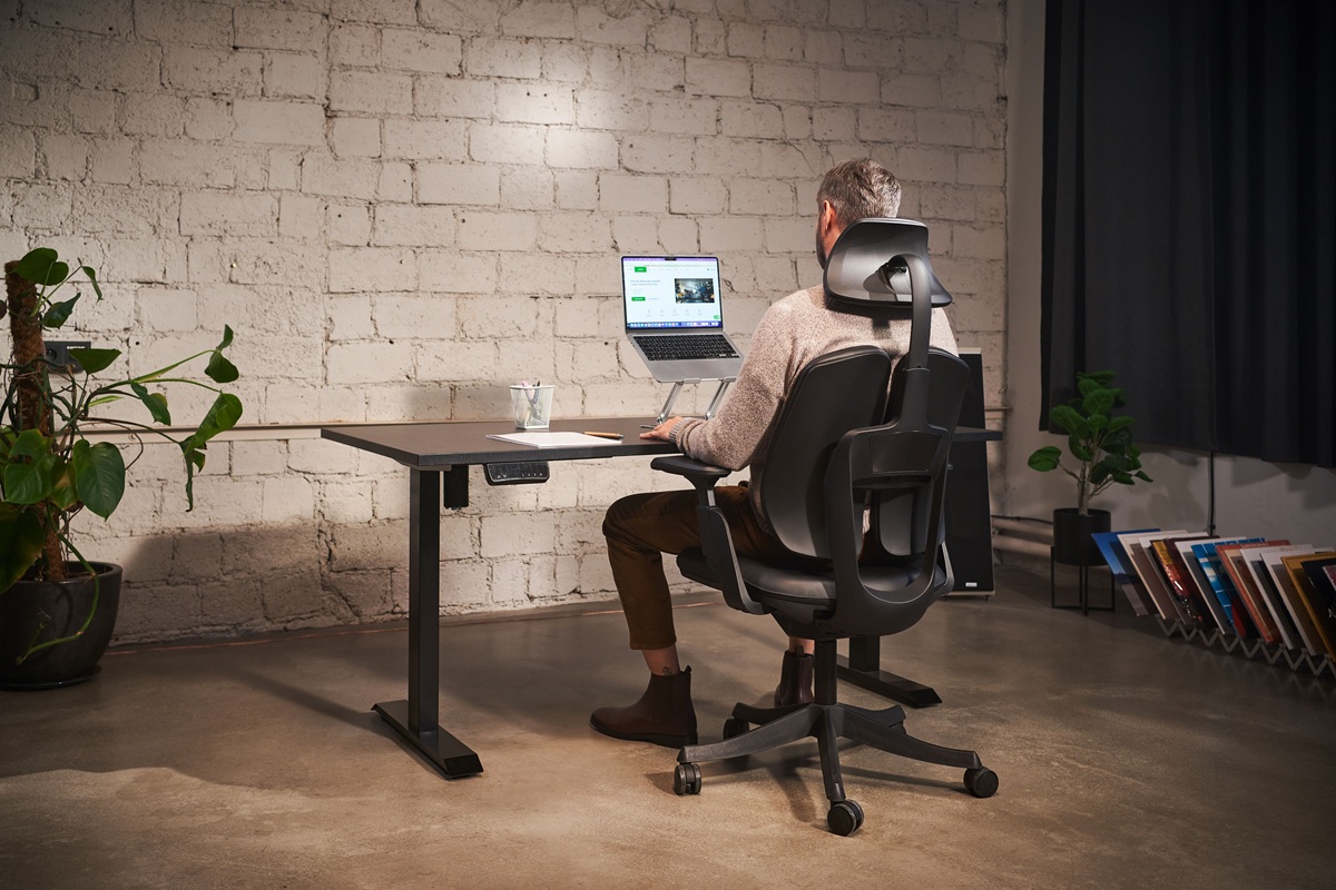 Ergonomisches Arbeiten am Laptop mit B&uuml;rostuhl und Laptopst&auml;nder am Schreibtisch